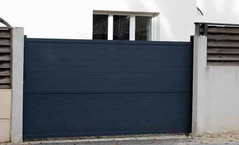 Anthrazitfarbenes Schiebetor mit waagerechter Blechfüllung in einer Grundstückseinfahrt — Metallbau Rudow