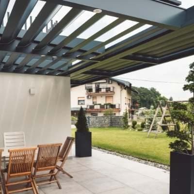 Lamellen-Pergola aus Aluminium am Haus – Beispiel für Wintergarten Potsdam
